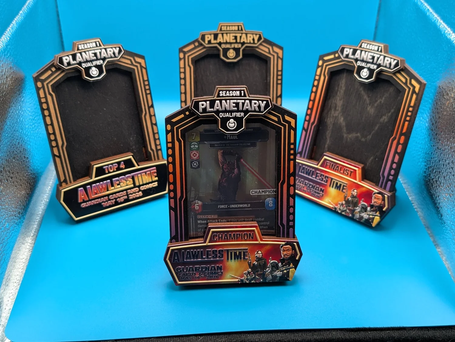 A set of engraved Planetary Qualifier prize frames staged as tournament prize support.